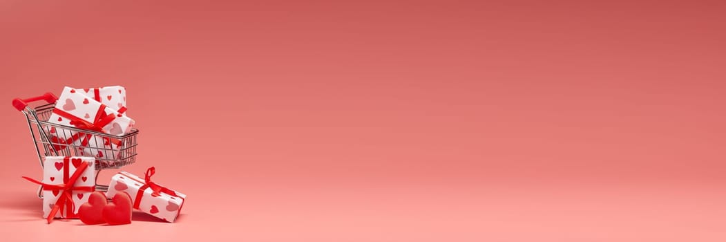 Shopping trolley with gift boxes and red hearts on pink background with copy space. Valentine's Day. Wedding day. Extra wide panorama banner background