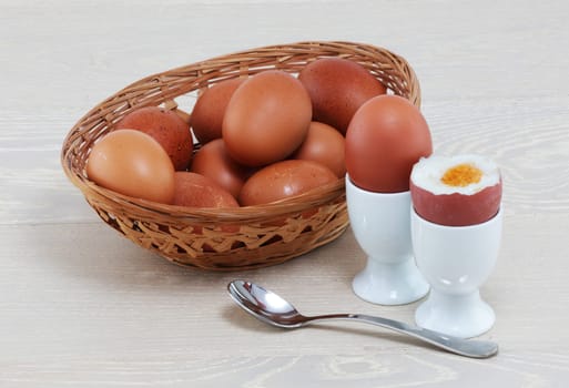 A boiled egg with basket of eggs eggcups