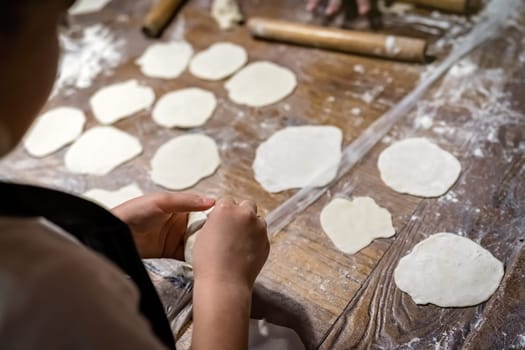 Girl learning to make traditional chinese dumplings during cooking class in a travellers hostel, Chengdu, Sichuan Province, China