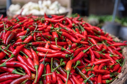 Red hot Chillies for sale stored in a large round wicker bow on a street market in China
