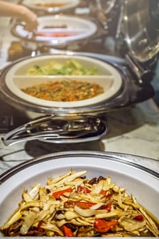 Fried noodles and boiled pakchoy in a serving bowl as a asian style breakfast buffet on the table in hotel cafeteria, China