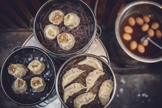 Delicious traditional chinese dumplings steamed and filled with pork meat, prepared on hot steam, China