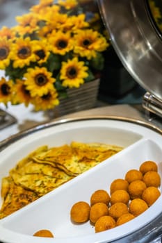 Egg pancakes and egg balls in breadcrumb in a serving bowl as a asian style breakfast buffet on the table in hotel cafeteria, China