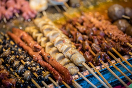 Portions of meat, seafood and cut vegetables on wooden sticks, ready to be grilled on the street in the Muslim Quarter, Xian town, China
