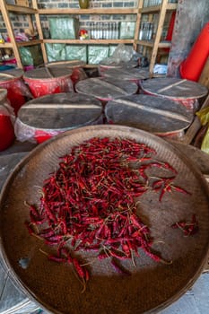 Chillies drying in a large round wicker bowl in a small mountain village in China