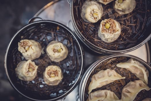 Delicious traditional chinese dumplings steamed and filled with pork meat, prepared on hot steam, China