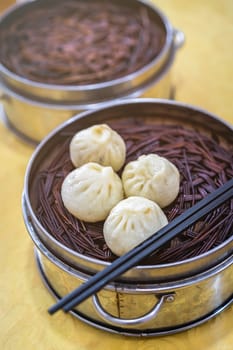 Delicious traditional chinese Baozi buns, steamed buns filled with ground pork meat and cabbage prepared on hot steam, steamed. China