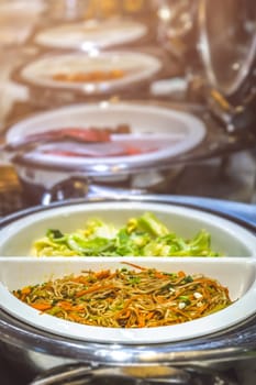 Fried noodles and boiled pakchoy in a serving bowl as a asian style breakfast buffet on the table in hotel cafeteria, China
