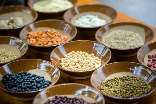 Small porcelain bowl with variety of grains to taste before the sale in a market in a small chinese town