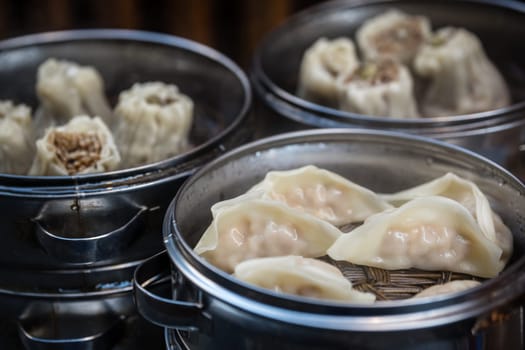 Delicious traditional chinese dumplings steamed and filled with pork meat, prepared on hot steam, China