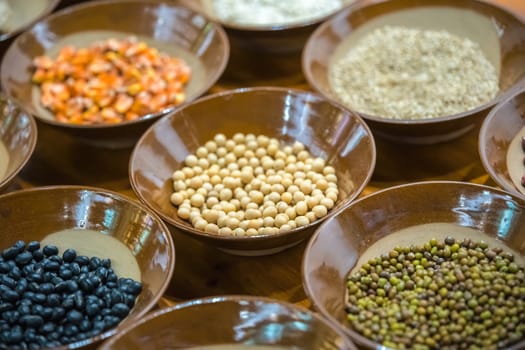 Small porcelain bowl with variety of grains to taste before the sale in a market in a small chinese town