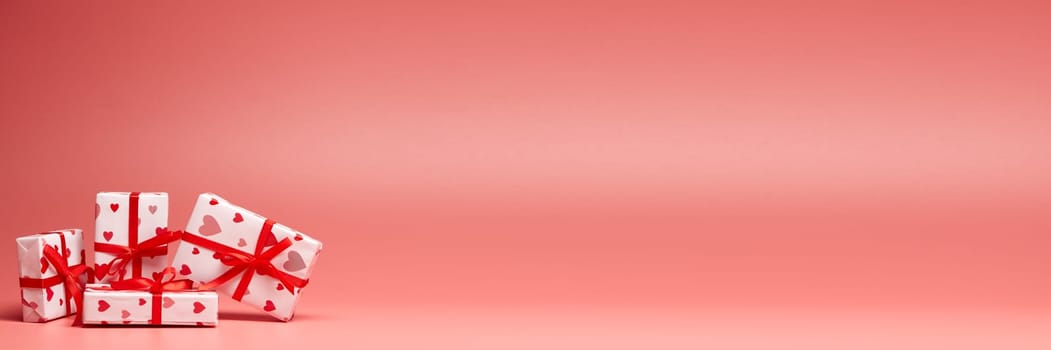 Gift boxes on pink background with copy space. Valentine's Day. Mother's day, wedding, women's day. Extra wide panorama banner background