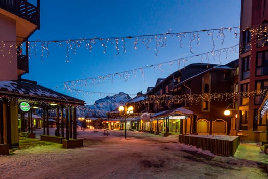 Les deux Alpes, Alps, France, January 2017 Nightlife in alpine village with traditional wooden houses, shops and restaurants. Popular ski destination