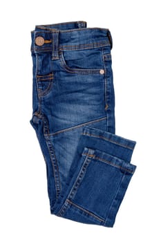 Fashionable denim clothes. Folded trendy stylish male denim stretch pants or trousers isolated on a white background. Fashionable blue jeans for child boy.