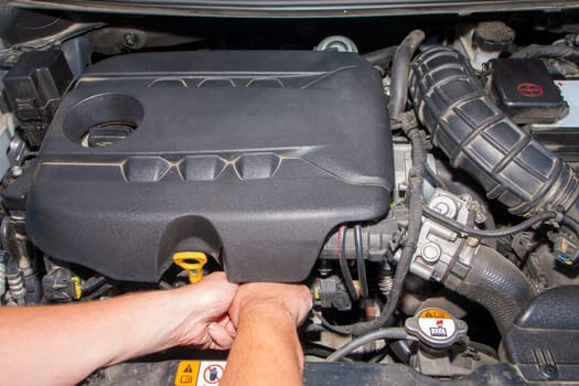 The visible hands of a mechanic. Mechanic repairs engine car. Modern diesel engine.