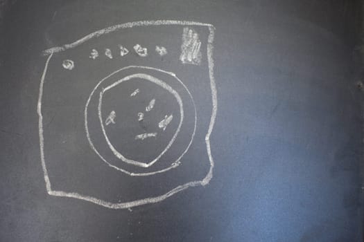 Drawing of a wash machine on a blackboard. Drawing made by child.
