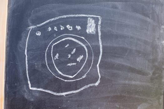 Drawing of a wash machine on a blackboard. Drawing made by child.