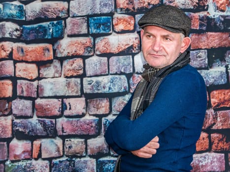 A man in a cap against a brick wall. People. Place for text. Background image. Photo model. Fashion.