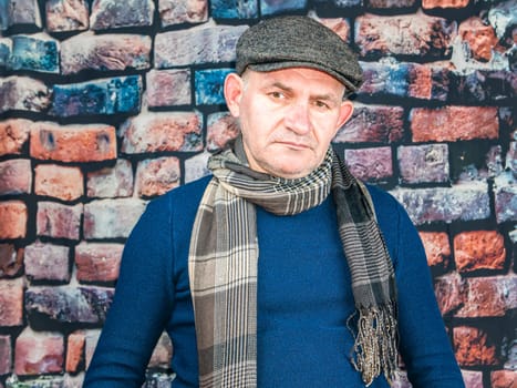 A man in a cap against a brick wall. People. Place for text. Background image. Photo model. Fashion.
