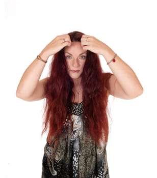 A lovely woman smiling and holding her long messy red hair on the .side, isolated for white background.