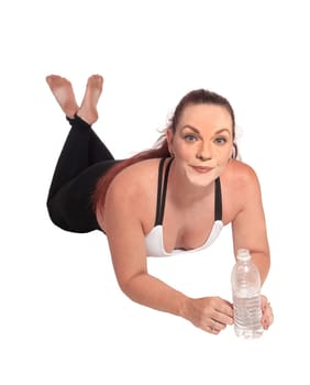 A woman in exercise outfit lying on the floor on her stomach and.holding a water bottle in her hand, isolated for white background.