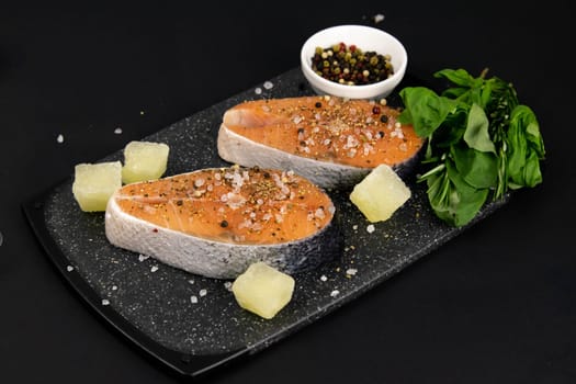 A set of healthy balanced super food, avocado in the foreground, fresh salmon, vegetables, cereals and nuts on a black background. Top view, flat lay