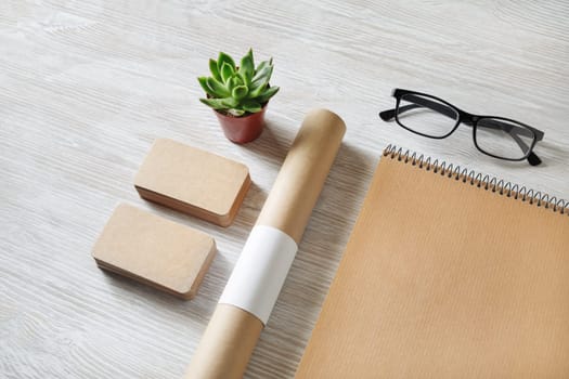 Blank kraft stationery set. Business brand template on light wooden background.