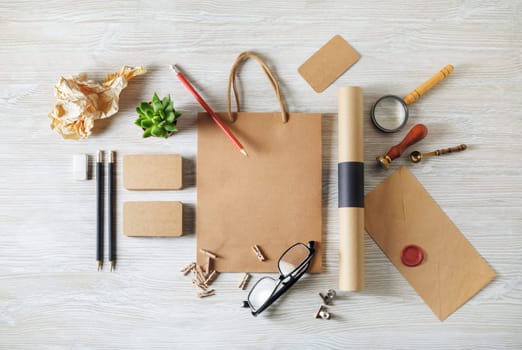 Blank kraft corporate stationery set on wooden background. Branding mock up. Flat lay.