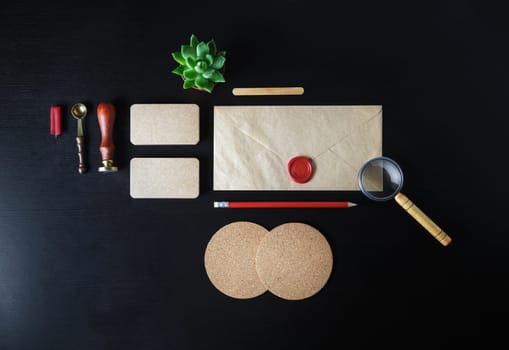 Blank kraft stationery and corporate identity template on black wooden background. Responsive design mockup. Flat lay.