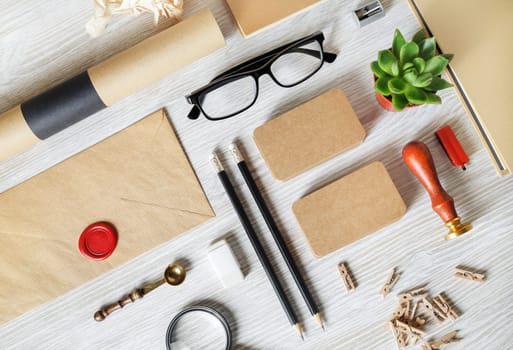 Blank kraft stationery and corporate identity template on light wooden background. Responsive design mockup. Flat lay.