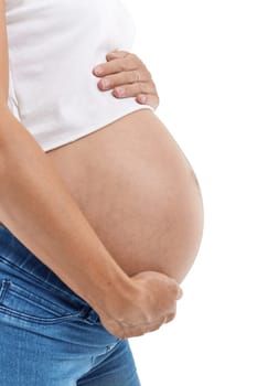 Pregnant woman embracing belly is standing  isolated on a white background.