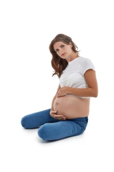 Young pregnant woman is sitting isolated on white background.