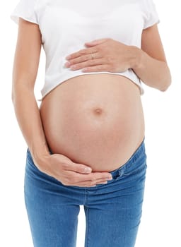 Pregnant woman embracing belly is standing  isolated on a white background.