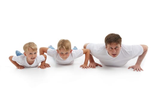 Father  with two sons. Young man with children isolated on a white background are doing gymnastic exercises. Push-ups. Parenting, Concept of healthy lifestyle, people and family