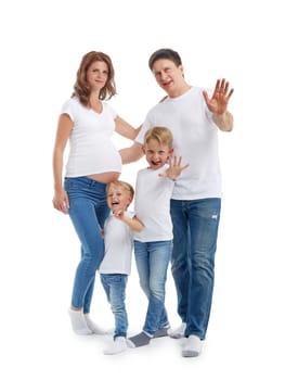 Happy parents: pregnant mother and father with lovely two sons are stand hugging, smiling and wave their hands, isolated on a white background. Happy friendly family. Concept of people and family