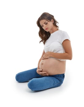 Young pregnant woman is sitting isolated on white background.