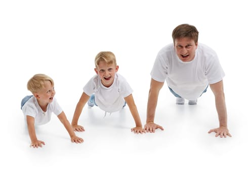 Father  with two sons. Young man with children isolated on a white background are doing gymnastic exercises. Push-ups. Parenting, Concept of healthy lifestyle, people and family