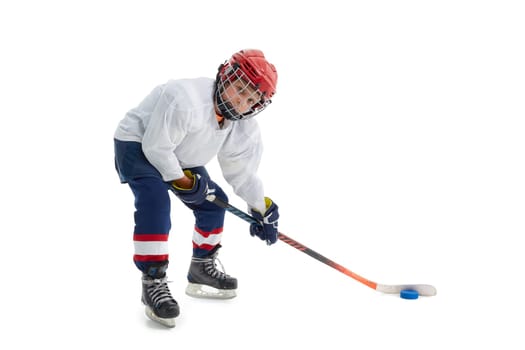 Junior ice hockey player . Child (boy) is hockey player in uniform with full equipment isolated on white background. Concept of children's sport, winter sport, healthy lifestyle.