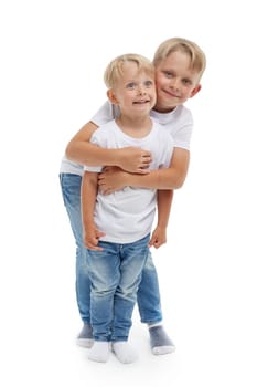 Friendly family. Older brother is hugging younger boy, standing isolated on a white background. Happy siblings. Two little brothers. Concept of people and family