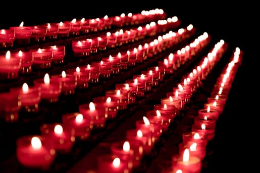 Candlelight fire flames in rows are silent religion symbol for peace, life and soul. Obituary hope sacrifice against sorrows and pain.