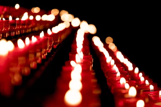 Candlelight fire flames in rows are silent religion symbol for peace, life and soul. Obituary hope sacrifice against sorrows and pain.