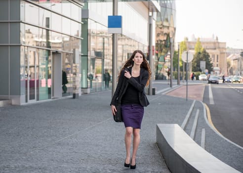 Young business woman in hurry - walking street with notebook bag
