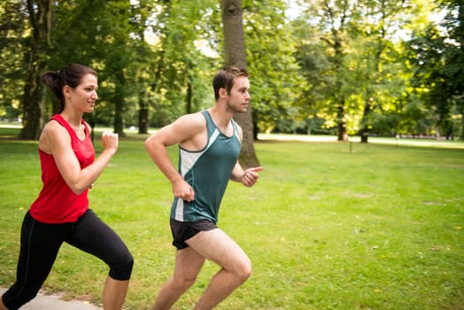 Fitness couple - young man and woman jogging outdoor in nature