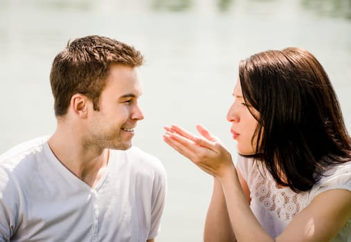 Young woman man blowing to hands, happy man is standing against