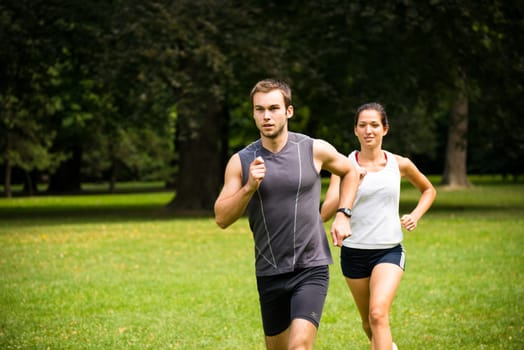 Young fitness couple jogging outdoor, man first