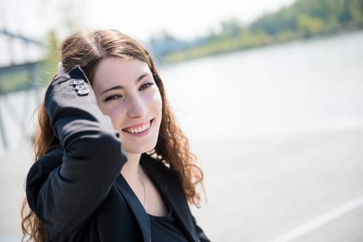Young smiling happy woman - natural outdoor portrait, hand in hair