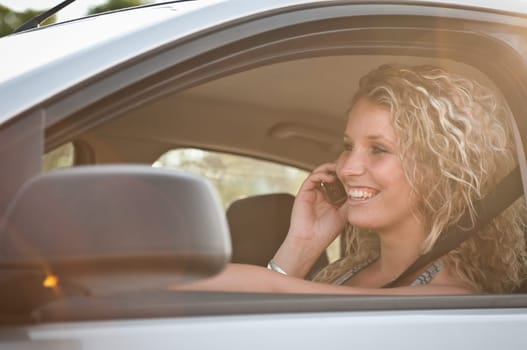 Portrait of young smiling woman driving car