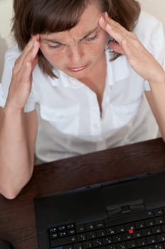 Business woman with headache in work