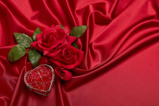 Abstract background from red silk (satin), roses and heart. Fabric texture with draped. Top view with copy space. Element design. Valentine's day. Wedding day.  Women' s day. Greeting card