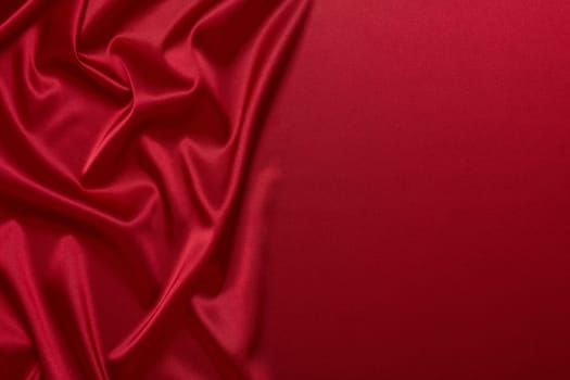 Abstract background from red silk or satin. Luxury fabric texture with draped. Top view with copy space. Element design. Valentine's day.